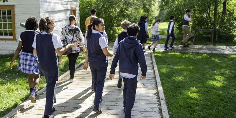 uniformed kids walking down paved path