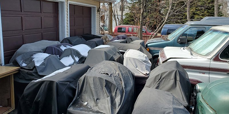 Driveway full of barbecues and cars