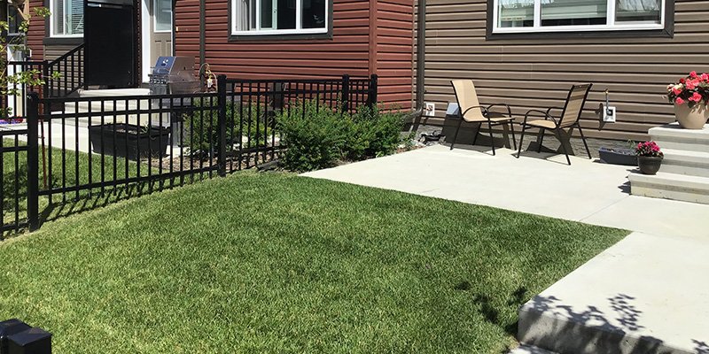 A graded lawn next to a multi-family house.