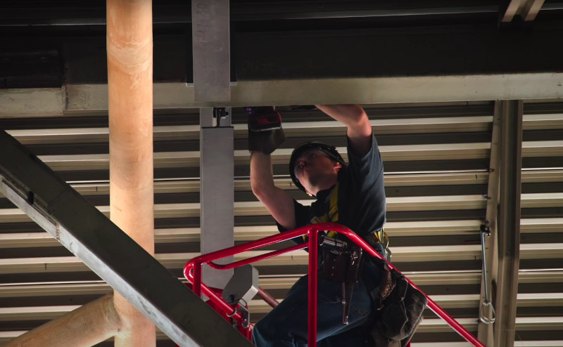 Tradesperson in crane lift working on beam