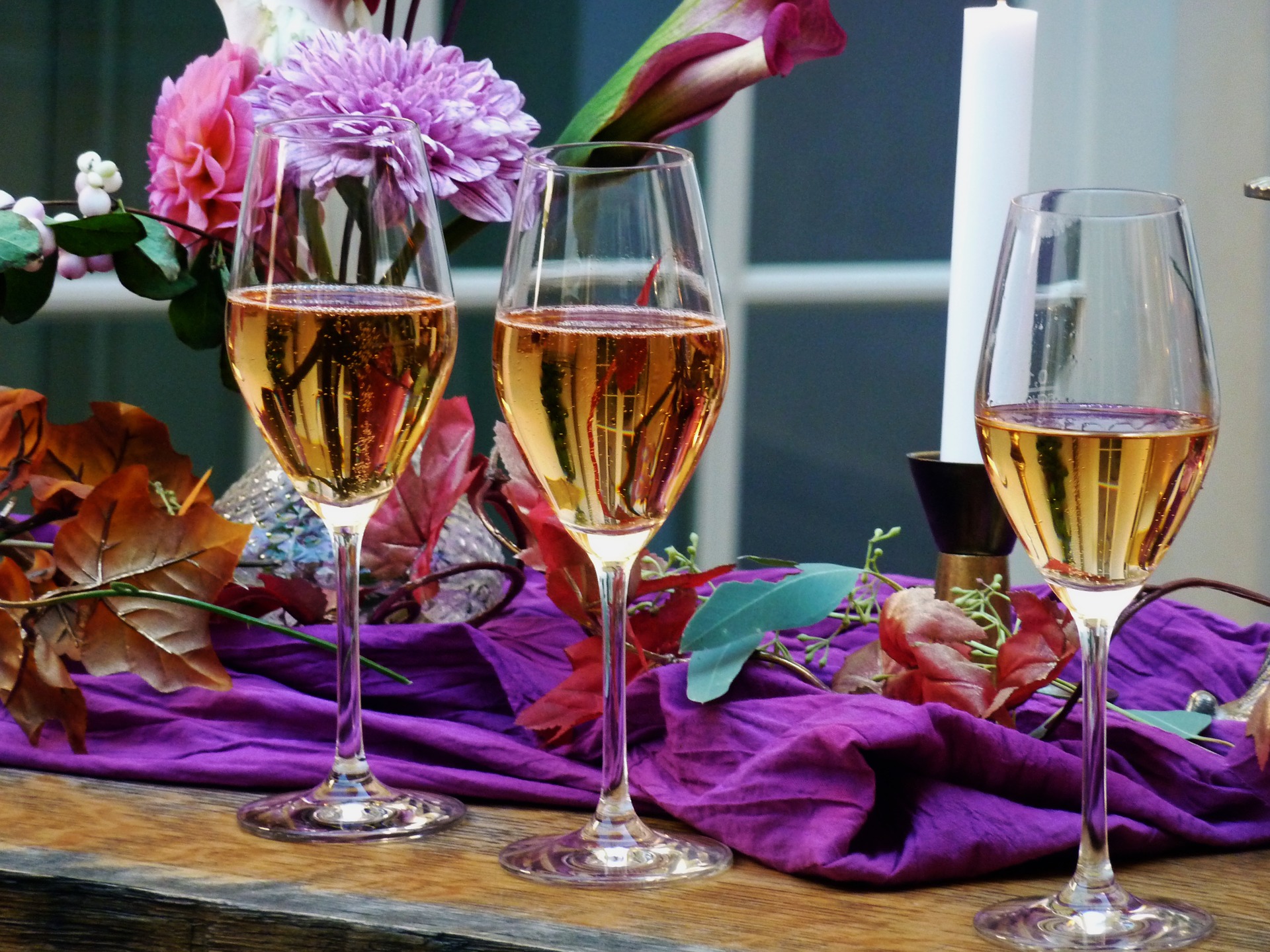 Two glasses of wine on a table with a bouquet of flowers