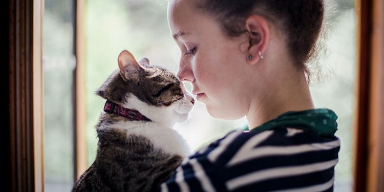 girl cuddling cat