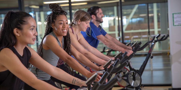 persons on stationary bikes in gym