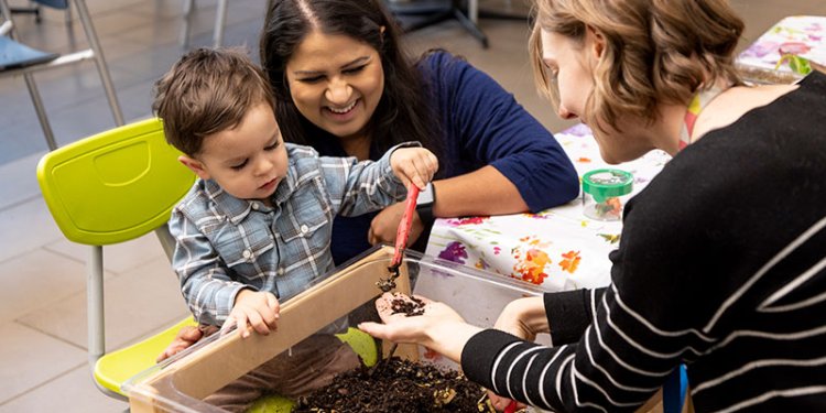 adults with child playing in soil