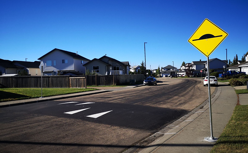 permanent speed hump with signage alerting drivers