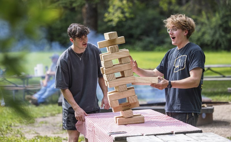 Two people playing a giant tower block game