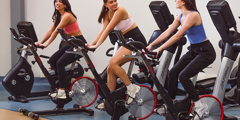 women on spin bikes at gym